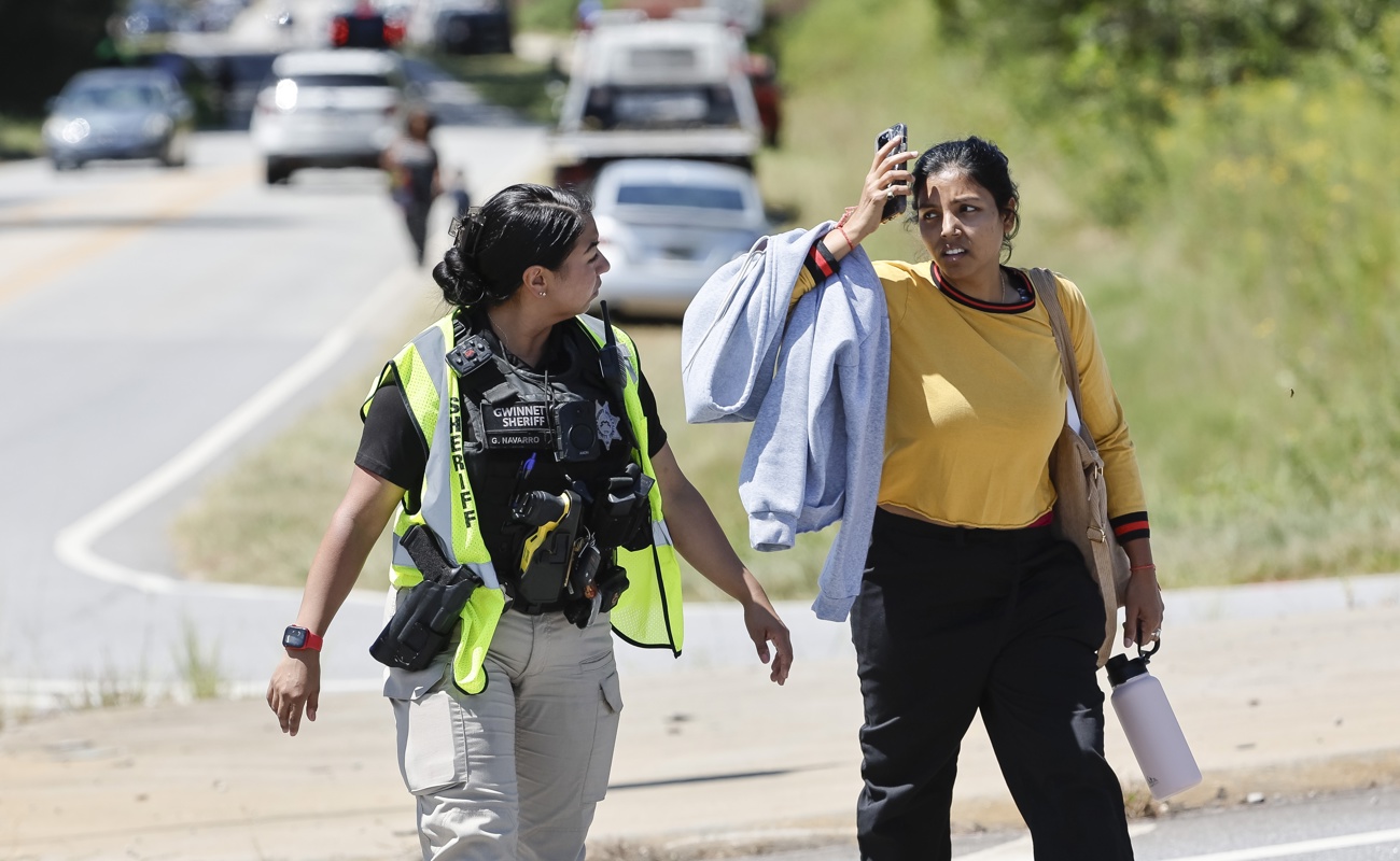 Un oficial de policía habla con una mujer cerca de la escena de un tiroteo reportado en Apalachee High School en Winder, Georgia, EUA, el 4 de septiembre de 2024. (Foto de Erik S. Lesser de la agencia EFE)