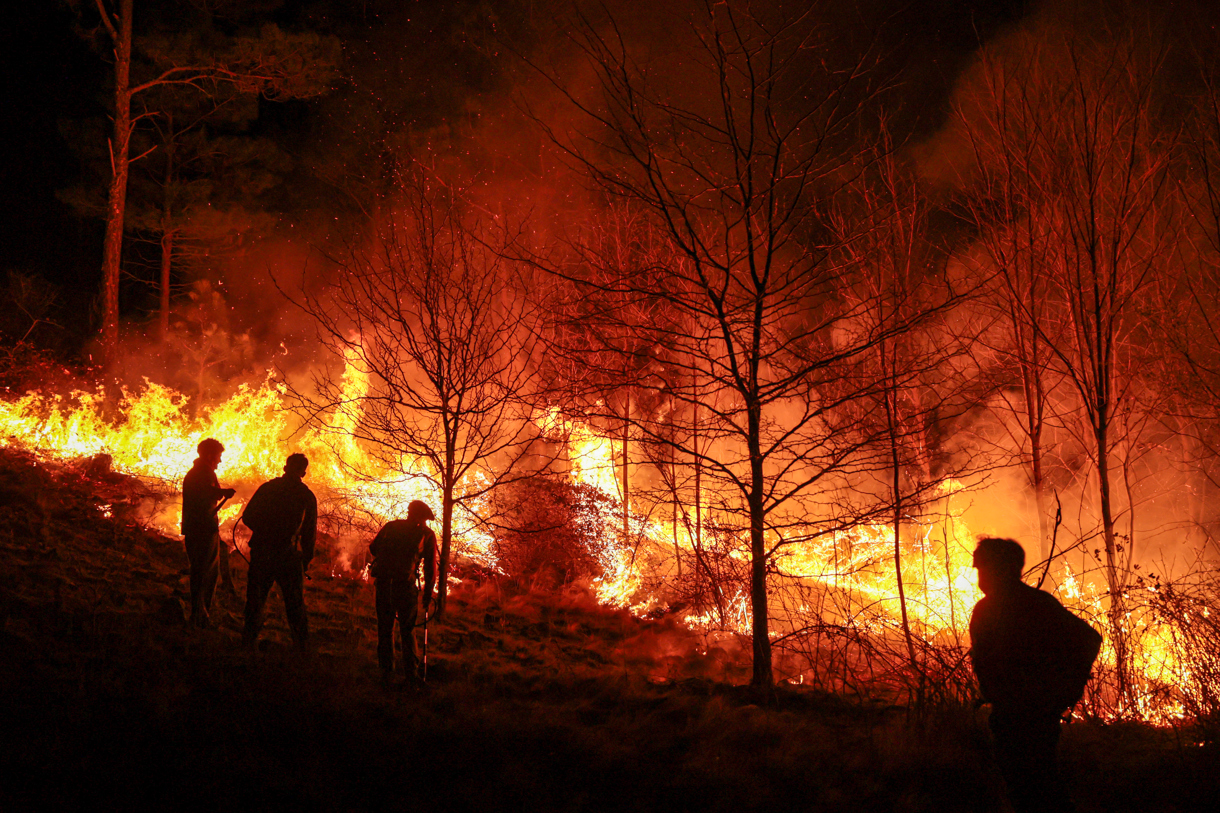 Personas parte de un grupo de bomberos y vecinos autogestionados combaten un incendio forestal este lunes, en Intiyaco en las cercanías de Villa Berna, provincia de Córdoba (Argentina). (Foto de STR de la agencia EFE)