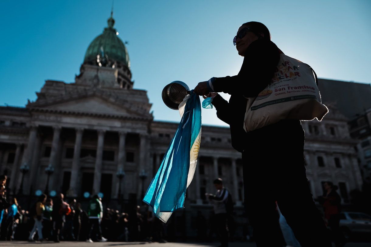 Fotografía del 4 de septiembre de 2024 en donde se ve a una mujer que sostiene una bandera de Argentina durante una marcha contra el veto presidencial a la ley de jubilaciones, frente al Congreso Nacional en Buenos Aires (Argentina). (Foto Juan Ignacio Roncoroni de la agencia EFE)