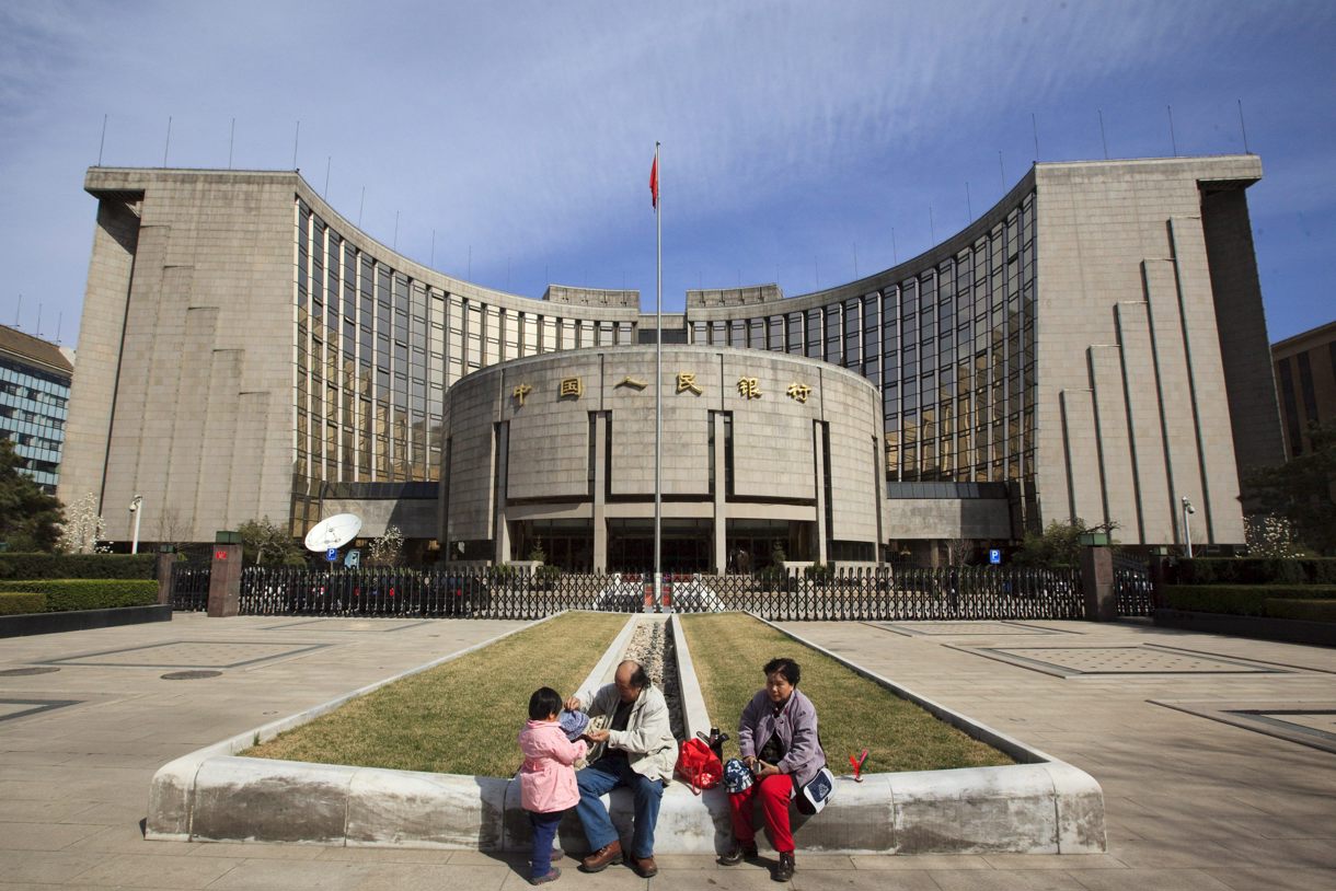 Una familia descansa delante de la sede del Banco Popular de China (Banco Central, BPC) en Pekín (China), el 26 de marzo de 2009. (Foto de Adrian Bradshaw de la agencia EFE)