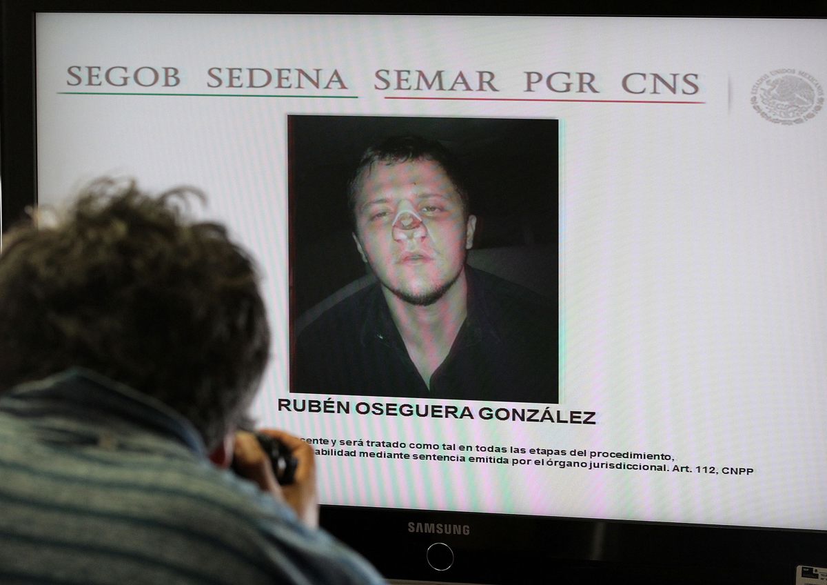 Un fotógrafo toma imágenes a una pantalla con el rostro de Rubén Oseguera González, alias “El Menchito” durante rueda de prensa en Ciudad de México (México). (Foto de archivo Alex Cruz de la agencia EFE)