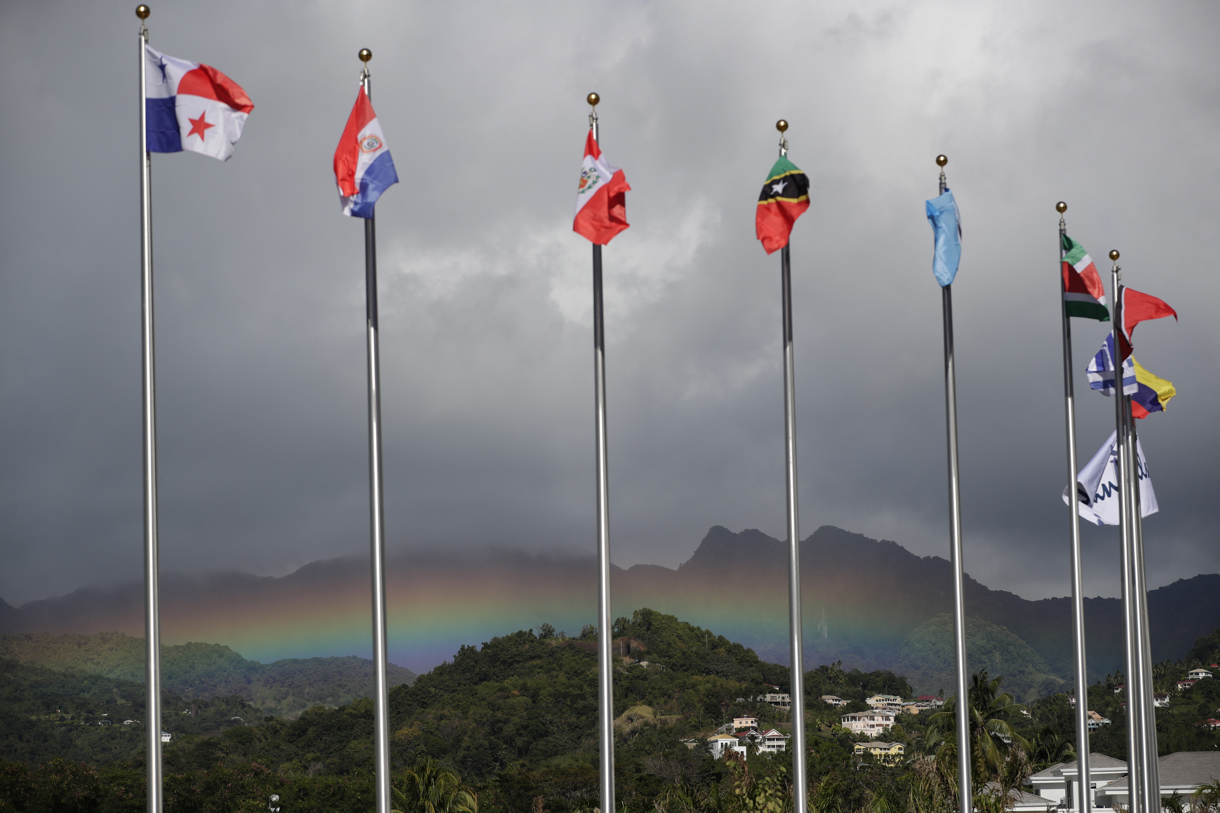 Fotografía de archivo del 1 de marzo de 2024 que muestra banderas de algunos países con el arcoíris de fondo, en Kingstown (S. Vicente y Granadinas). (Foto de Bienvenido Velasco de la agencia EFE)