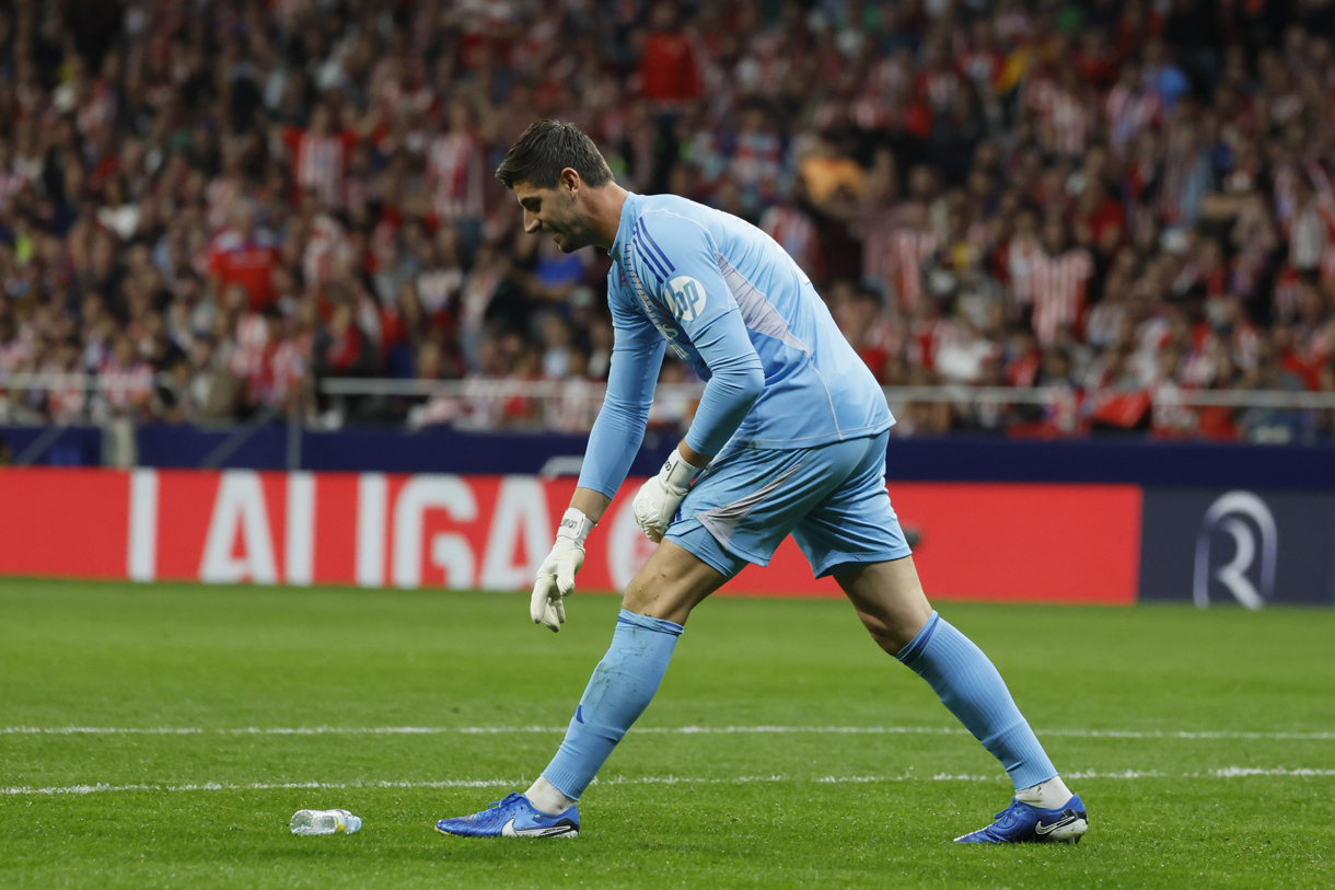 El portero del Real Madrid Thibaut Courtois retira un objeto lanzado desde la grada, durante el partido de la LaLiga EA Sports que Atlético de Madrid y Real Madrid disputaron en el estadio Civitas Metropolitano. (Foto de Ballesteros de la agencia EFE)