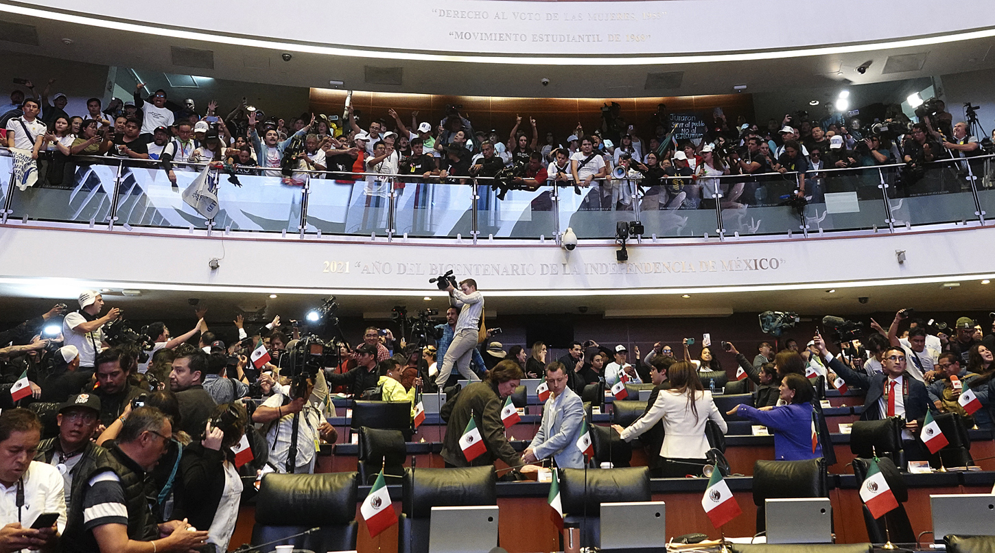 Trabajadores del poder judicial, irrumpen una sesión en contra de la reforma impulsada por el oficialismo ayer martes, en la Cámara de Senadores de Ciudad de México. (Foto de Madla Hartz de la agencia EFE)