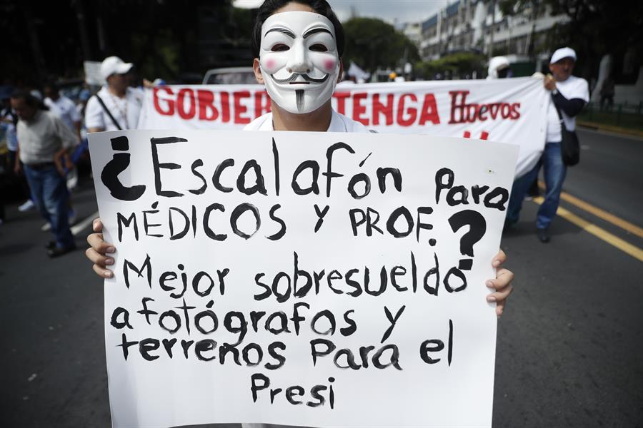 Un manifestante sostiene un cartel en una marcha este sábado en San Salvador, El Salvador. (Foto de EFE)