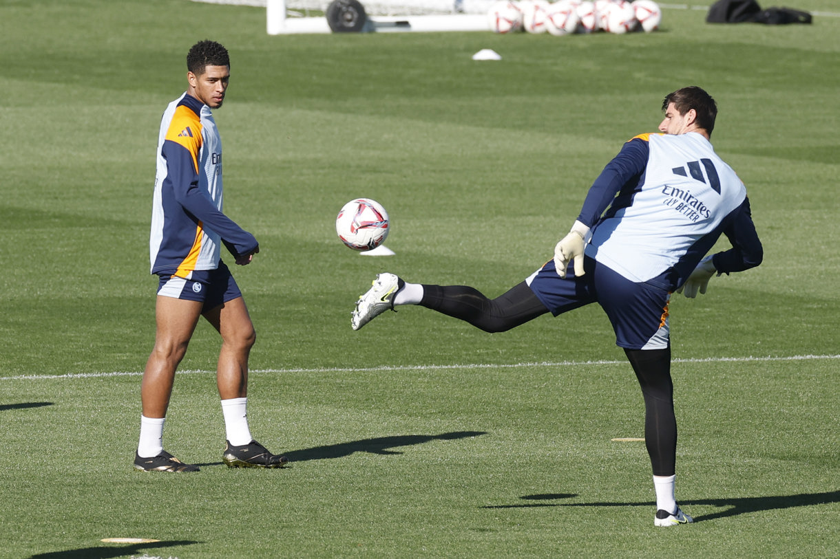 Thibaut Courtois (d) despeja el balón en presencia del centrocampista inglés Jude Bellingham. El portero belga ha sido incluido en la convocatoria para el partido ante el Celta de Vigo. (Foto de Juan Carlos Hidalgo de la agencia EFE)