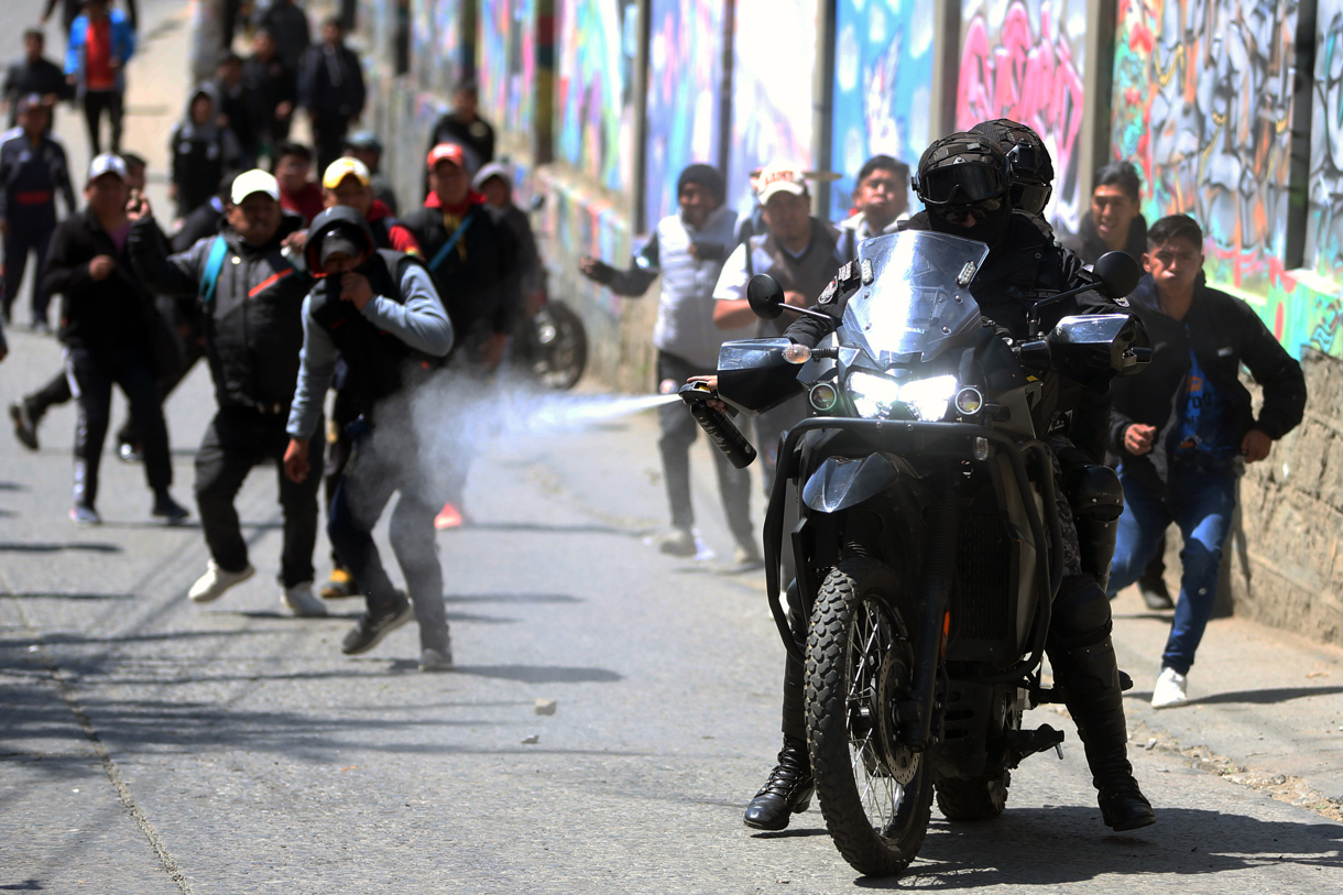 Un policía rocía gas pimienta durante una jornada protestas de conductores del transporte público este miércoles, en La Paz (Bolivia). (Foto de Luis Gandarillas de la agencia EFE)