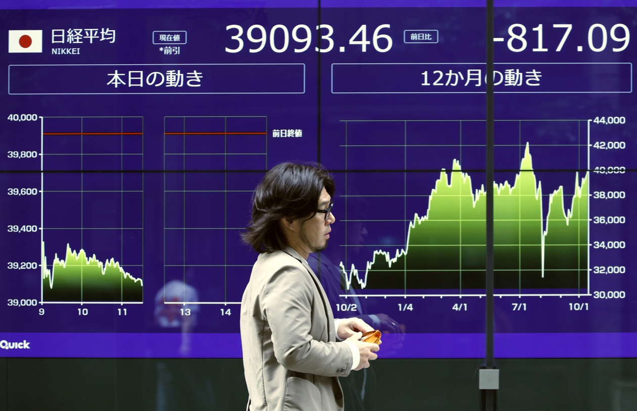 Foto de archivo de un transeúnte que pasa junto a un panel indicador del mercado de valores en Tokio, cuando la bolsa nipona cayó tras las pérdidas registradas en Wall Street. (Foto de Franck Robichon de la agencia EFE/EPA)