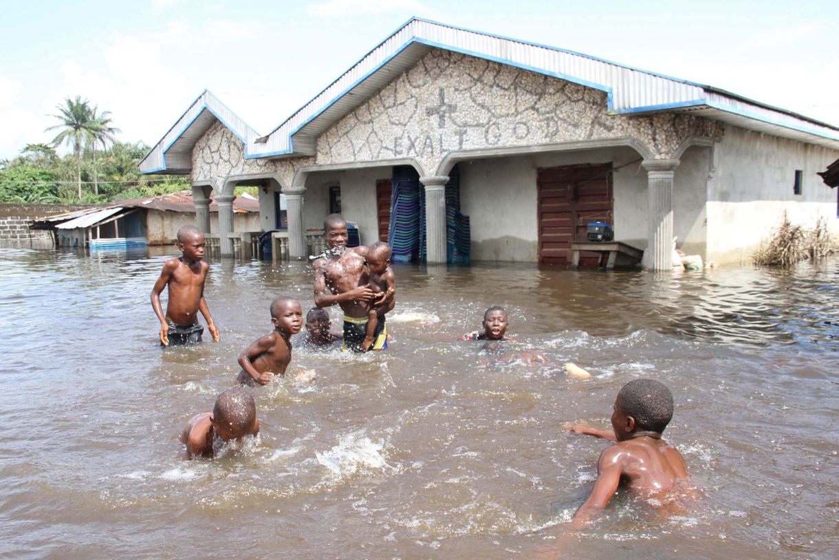 En la imagen de archivo, varios niños juegan en una calle inundada en Ughelli, en el delta del Níger, Nigeria. (Foto de George Esirii de la agencia EFE)