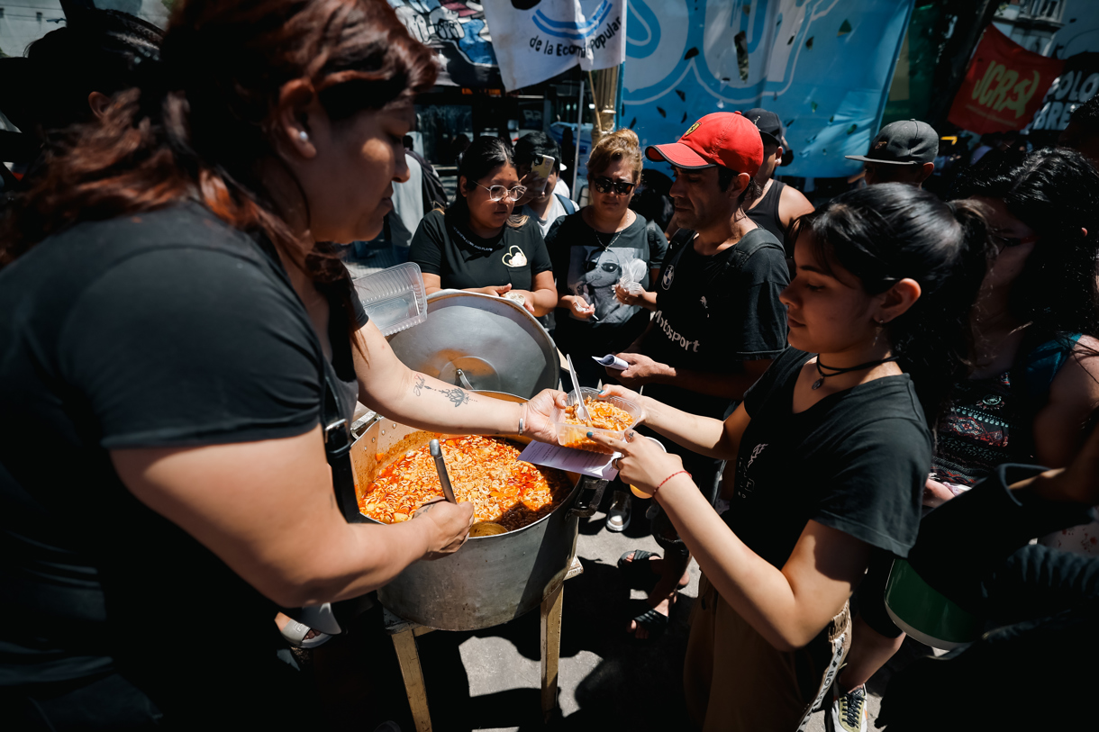 Organizaciones sociales reparten comida frente a la estación Plaza Constitución, una de las siete estaciones centrales de transporte de la ciudad, cerraba debido a una huelga este miércoles en Buenos Aires (Argentina). (Foto de Juan Ignacio Roncoroni de la agencia EFE)