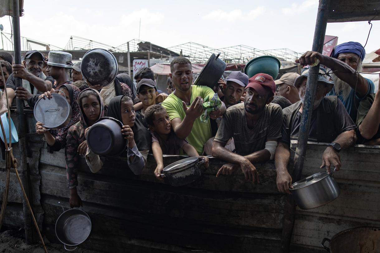 Fotografía de archivo en donde palestinos desplazados internos asisten a una reunión para recolectar alimentos donados por una organización benéfica, en el campamento de Khan Yunis, al sur de la Franja de Gaza, el 06 de septiembre de 2024. (Foto de Haitham Imad de la agencia EFE)