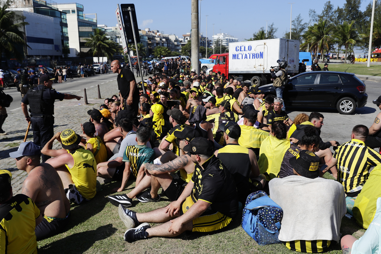 Fotografía tomada el 23 de octubre de 2024 a fanáticos del club Peñarol detenidos por la policía de Río de Janeiro por su presunta participación en disturbios antes del partido de ida de las Semifinales de la Copa Libertadores que ganó Botafogo por 5-0. (Foto de André Coelho de la agencia EFE)