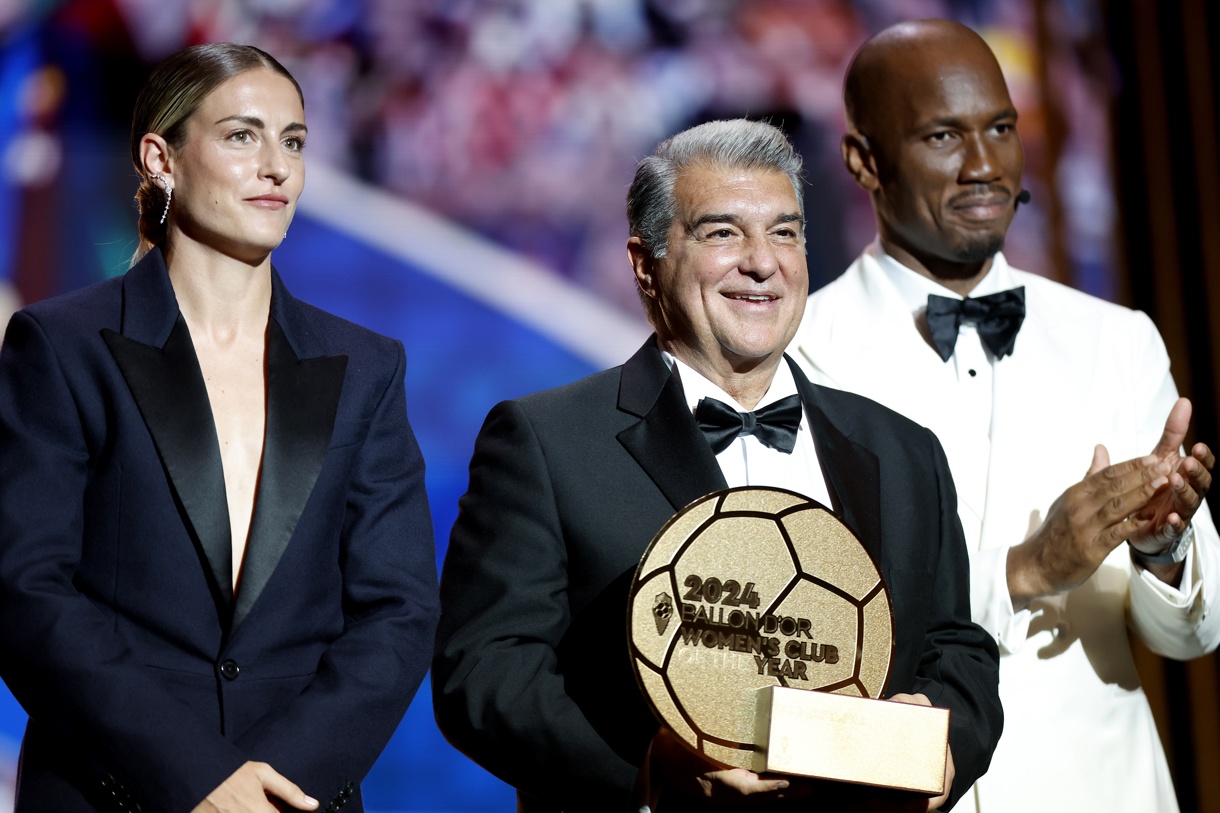 El co-anfitrión Didier Drogba (d) aplaude mientras el presidente del Barcelona Joan Laporta y la centrocampista del Barcelona Alexia Putellas aceptan el premio al Club Femenino del Año 2024 en nombre del equipo durante la ceremonia del Balón de Oro 2024 en el Theatre du Chatelet en París, Francia, 28 de octubre de 2024. (Foto de Mohammed Badra de la agencia EFE/EPA)