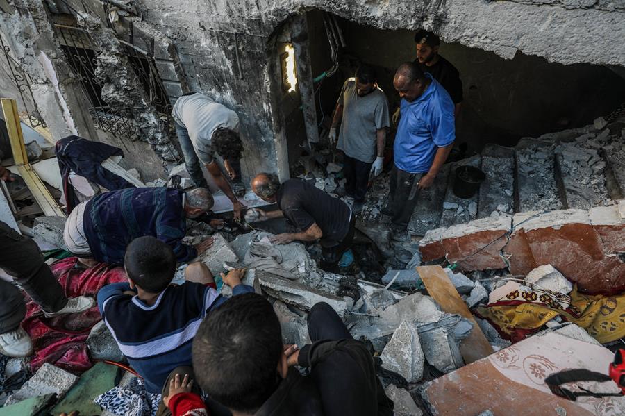 Palestinos buscan cadáveres y supervivientes entre los escombros de una casa destruida tras un ataque aéreo israelí en el campo de refugiados de Al Maghazi, en la Franja de Gaza, el 19 de octubre de 2024. (Foto de EFE)