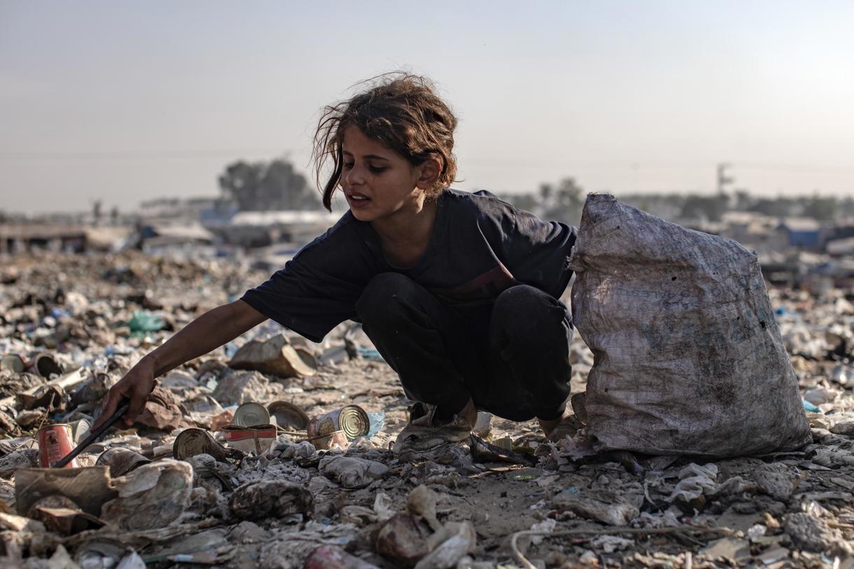 Un niño palestino revisa la basura mientras recoge plástico de un vertedero, en medio de una escasez de gas de cocina y combustible, en el sur de la Franja de Gaza, 04 de noviembre de 2024. (Foto de Haitham Imad de la agencia EFE/EPA)