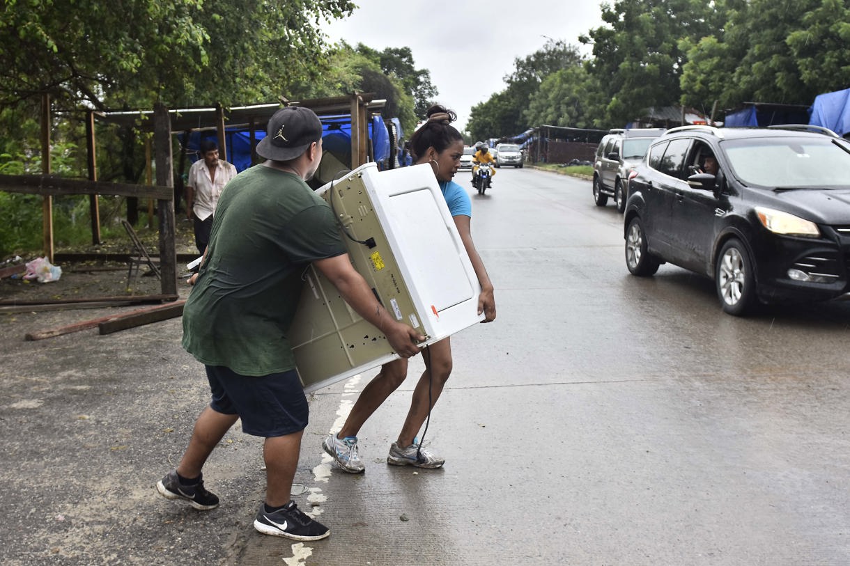 Pobladores transportan sus pertenencias luego de que el gobierno emitiera alerta roja y ordenara evacuar las zonas bajas de la costa norte de Honduras debido al aumento de las lluvias. Imagen de archivo. (Foto de José Valle de la agencia EFE)