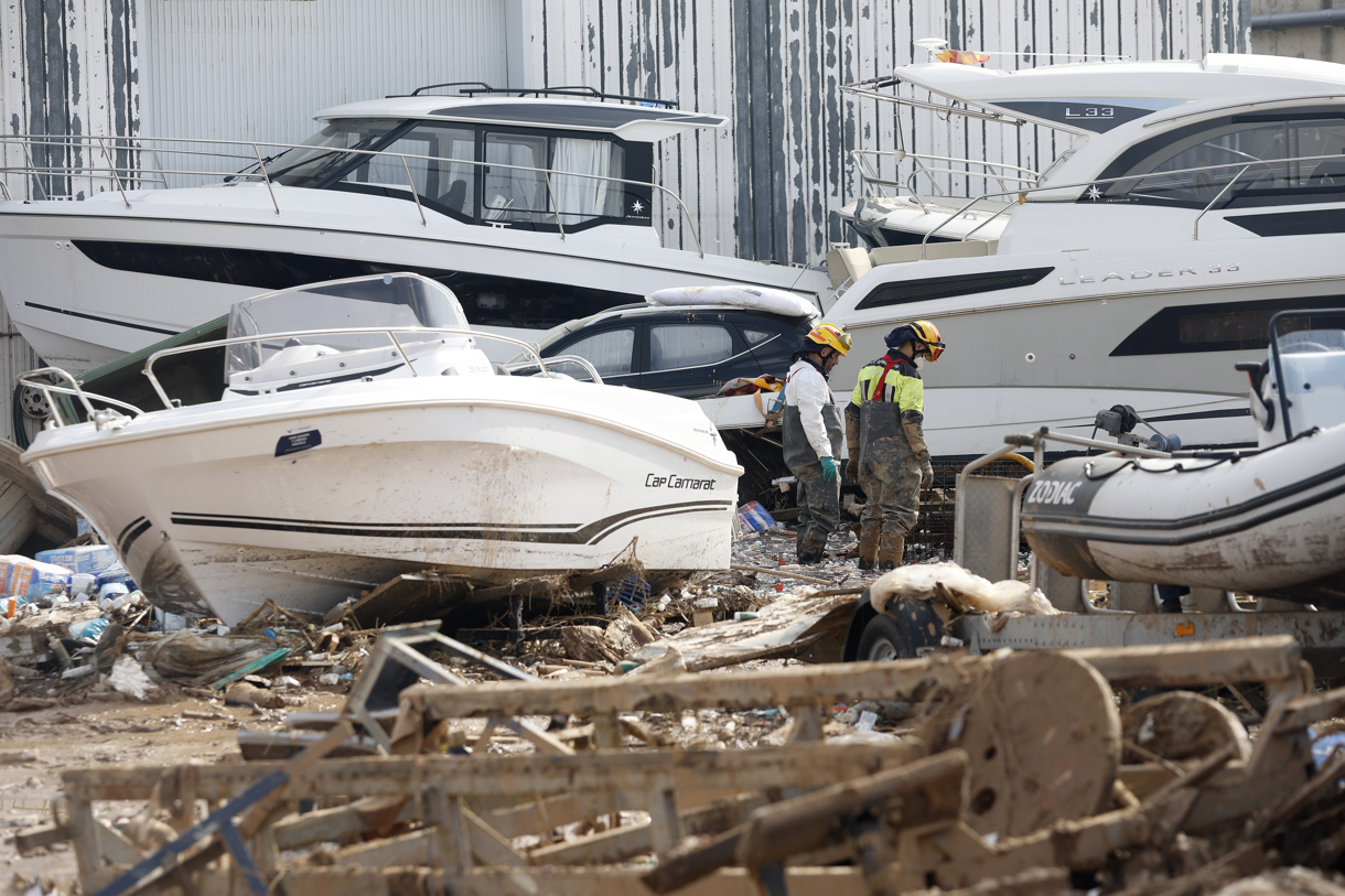 Dos bomberos inspeccionan las inmediaciones de una empresa con lanchas marinas en Massanassa, este miércoles. (Foto de Miguel Ángel Polo de la agencia EFE)