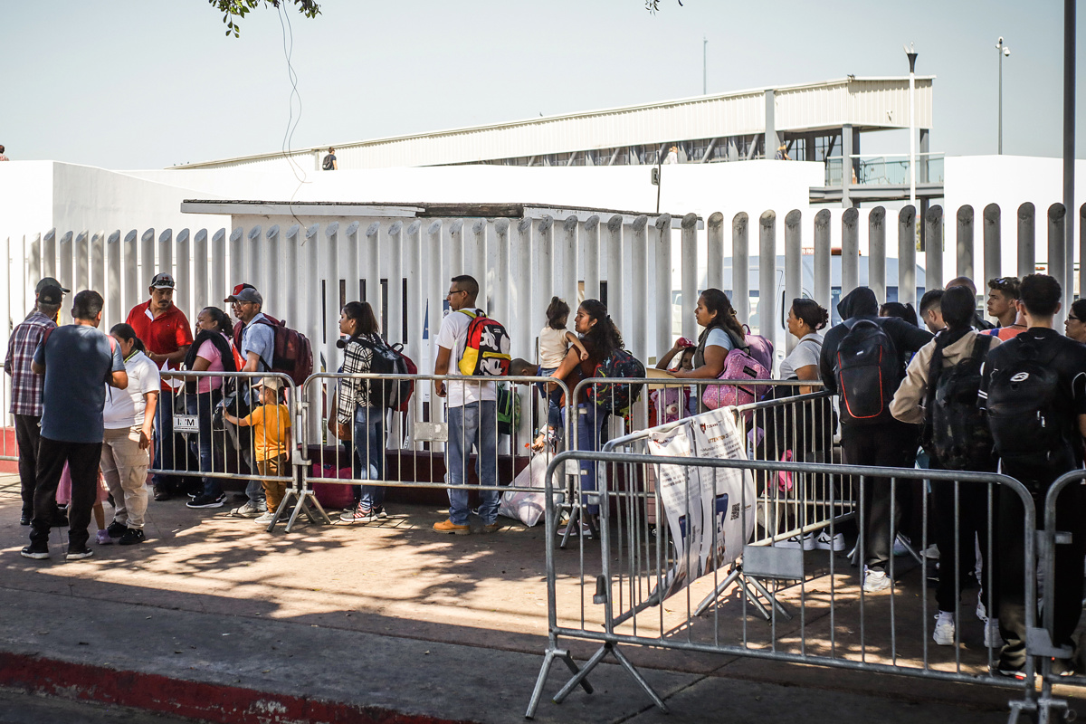 Fotografía de archivo en donde migrantes hacen fila en la garita el Chaparral para cruzar la frontera hacia Estados Unidos, en la ciudad de Tijuana, en Baja California (México). (Foto de Joebeth Terríquez de la agencia EFE)