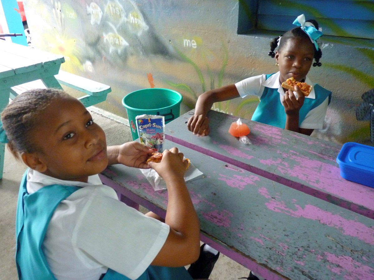 Fotografía de archivo en donde se ven 2 niñas mientras toman su refrigerio en una escuela a las afueras de Castries, capital de la isla caribeña de Santa Lucía. (Foto de Belén Delgado de la agencia EFE)