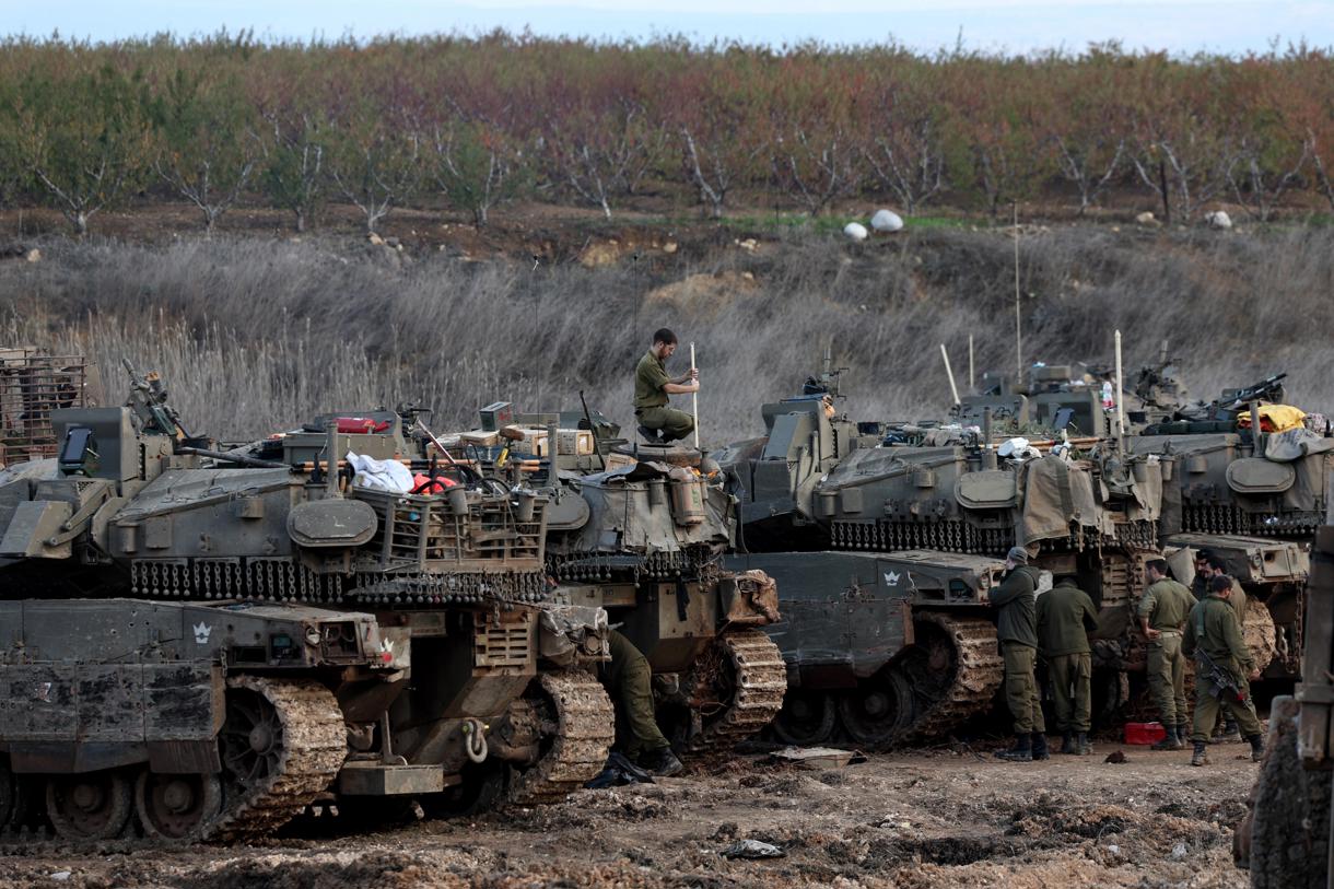 Soldados israelíes pasan junto a tanques estacionados en un campo al regresar a Israel tras un alto el fuego con Hizbulá, en Metula, en el norte de Israel, 28 de noviembre de 2024. (Foto de Atef Safadi de la agencia EFE/EPA)