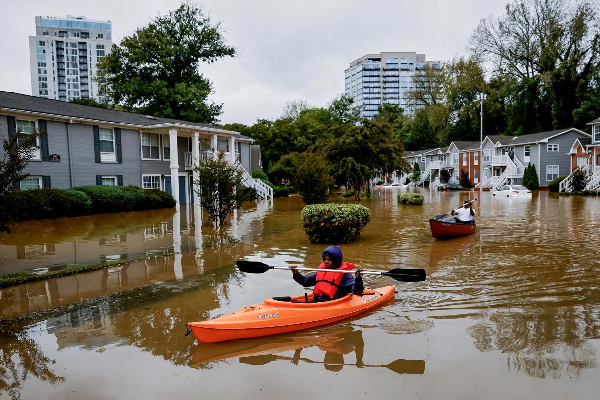 Fotografía de archivo fechada el 27 de septiembre de 2024 de Candice Ocvil (i) y Jibri Tolen (d), residentes de Peachtree Park, remando a través de las aguas de la inundación después de que la tormenta tropical Helene atravesó Atlanta, Georgia (EUA). (Foto de Erik S. Lesser de la agencia EFE/EPA)