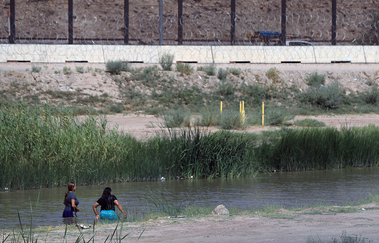 Fotografía de archivo en donde se ven 2 mujeres migrantes mientras cruzan el río Bravo (río Grande), frontera natural entre Estados Unidos y México. (Foto de Luis Torres de la agencia EFE)