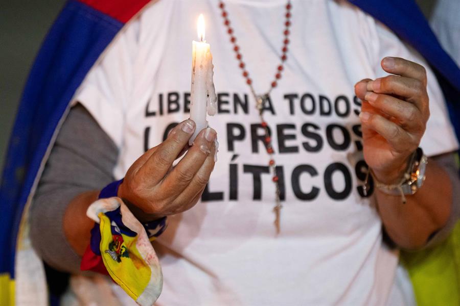 Fotografía de archive de EFE en donde se ve a una mujer mientras sostiene una vela durante una vigilia por los “presos politicos” en Caracas.