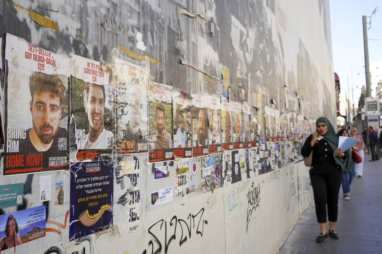 Una mujer camina este miércoles en una calle de Jerusalén delante de fotos de los rehenes israelíes secuestrados por Hamas el 7 de octubre del año pasado. (Foto de Alejandro Ernesto de la agencia EFE)