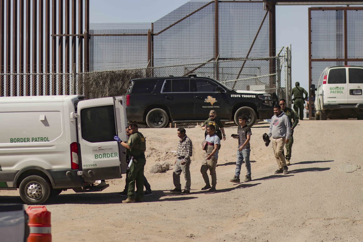 Migrantes detenidos son llevados por miembros de la Patrulla Fronteriza estadounidense a un vehículo, junto al muro fronterizo en El Paso, Texas (EUA). (Foto de archivo de Jonathan Fernández de la agencia EFE)