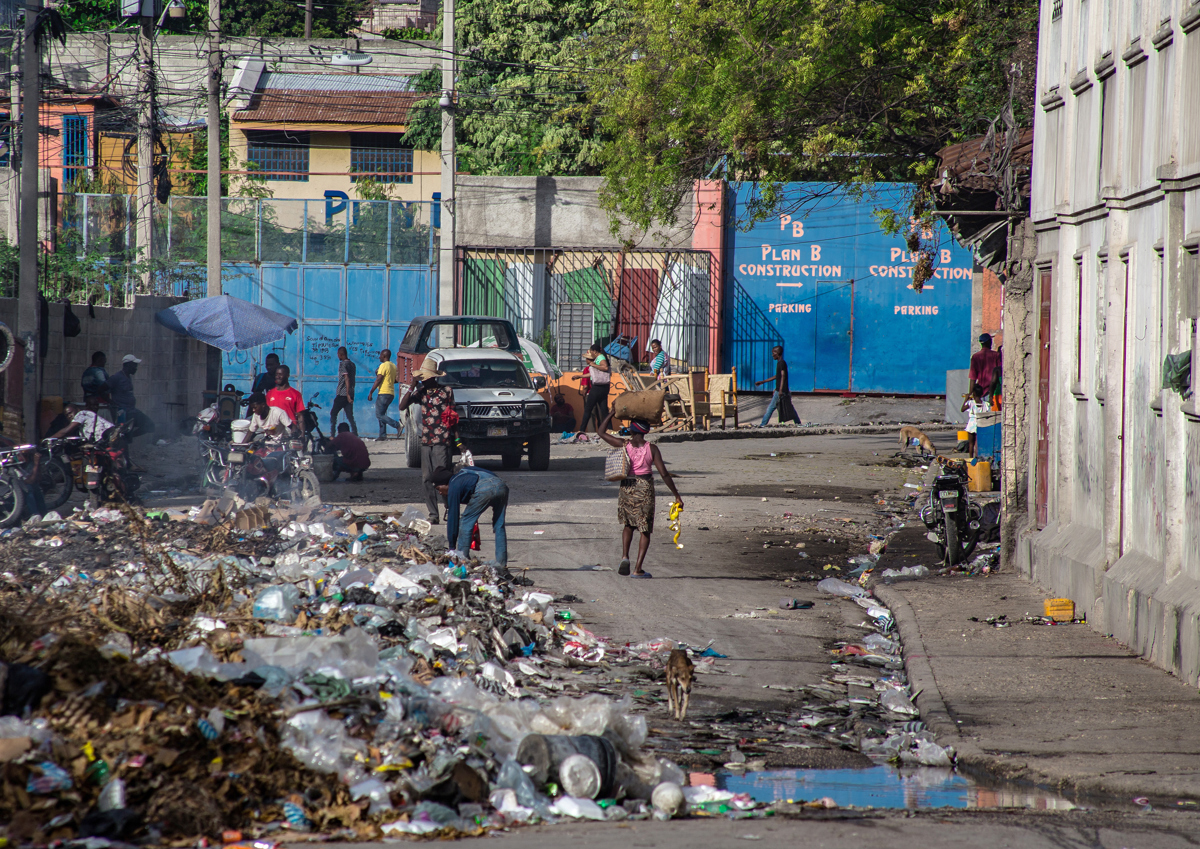 Personas caminan en medio de la basura por una calle cercana al Palacio Nacional, este lunes en Puerto Príncipe (Haití). (Foto de Mentor David Lorens de la agencia EFE)