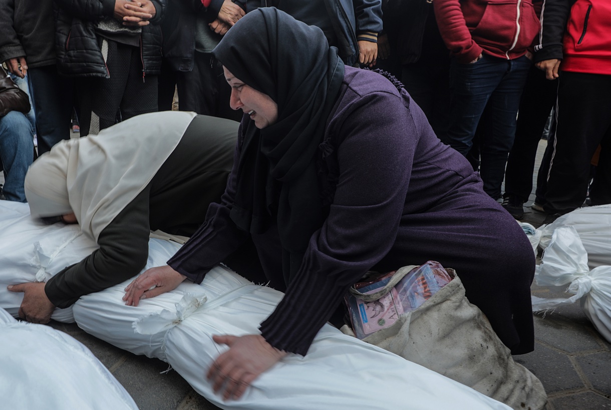 Mujeres palestinas lloran sobre los cuerpos cubiertos de los miembros de una familia palestina que fueron asesinados en un ataque aéreo israelí, en el Hospital de los Mártires de Al Aqsa en la ciudad de Deir Al Balah, en la franja de Gaza central, 15 de enero de 2025. (Foto de Mohammed Saber de la agencia EFE/EPA)