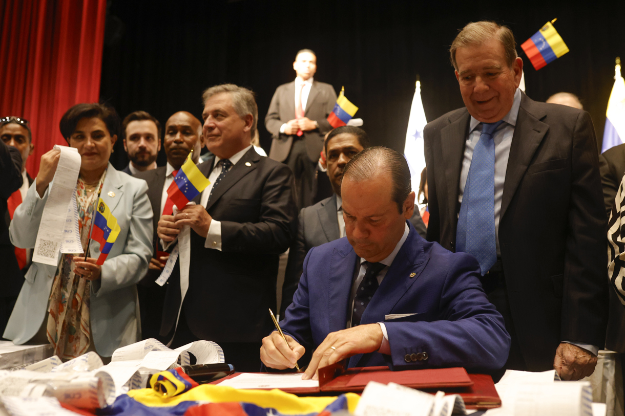 El canciller de Panamá Javier Martínez-Acha (2-d) firma un documento junto al líder opositor venezolano Edmundo González Urrutia (d) luego de presentar actas electorales este miércoles, en la Ciudad de Panamá (Panamá). (Foto de Bienvenido Velasco de la agencia EFE)