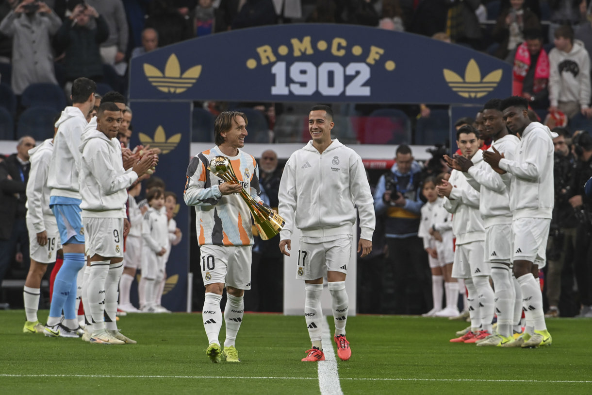 Los jugadores del Real Madrid Luka Modric (c-i) y Lucas Vázquez (c-d) muestran al público el Trofeo de la Copa Intercontinental, en el estadio Santiago Bernabéu. (Foto de archivo de Fernando Villar de la agencia EFE)