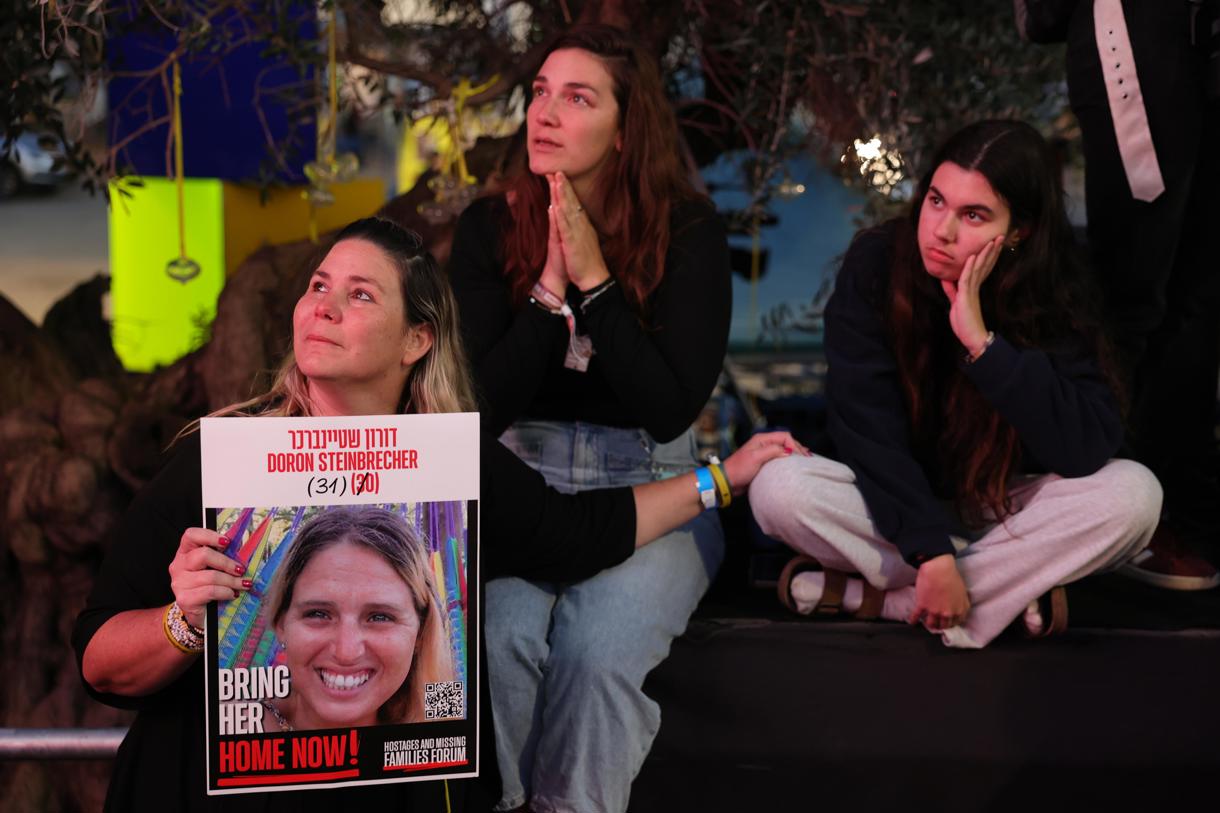 Varias personas observan una transmisión en vivo en una pantalla grande que informa sobre la liberación de 3 rehenes israelíes, Romi Gonen, Emily Damari y Doron Steinbrecher, transferidos de Hamas a la Cruz Roja. (Foto de Abir Sultan de la agencia EFE/EPA)