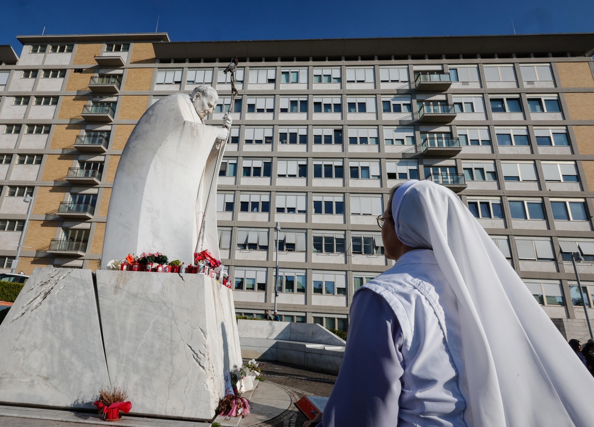 Una monja reza ante una estatua del Papa San Juan Pablo II fuera del Hospital Universitario Gemelli, donde el Papa Francisco está hospitalizado por tratamiento de bronquitis, en Roma, Italia, 21 de febrero de 2025. (Foto de Giuseppe Lami de la agencia EFE/EPA)