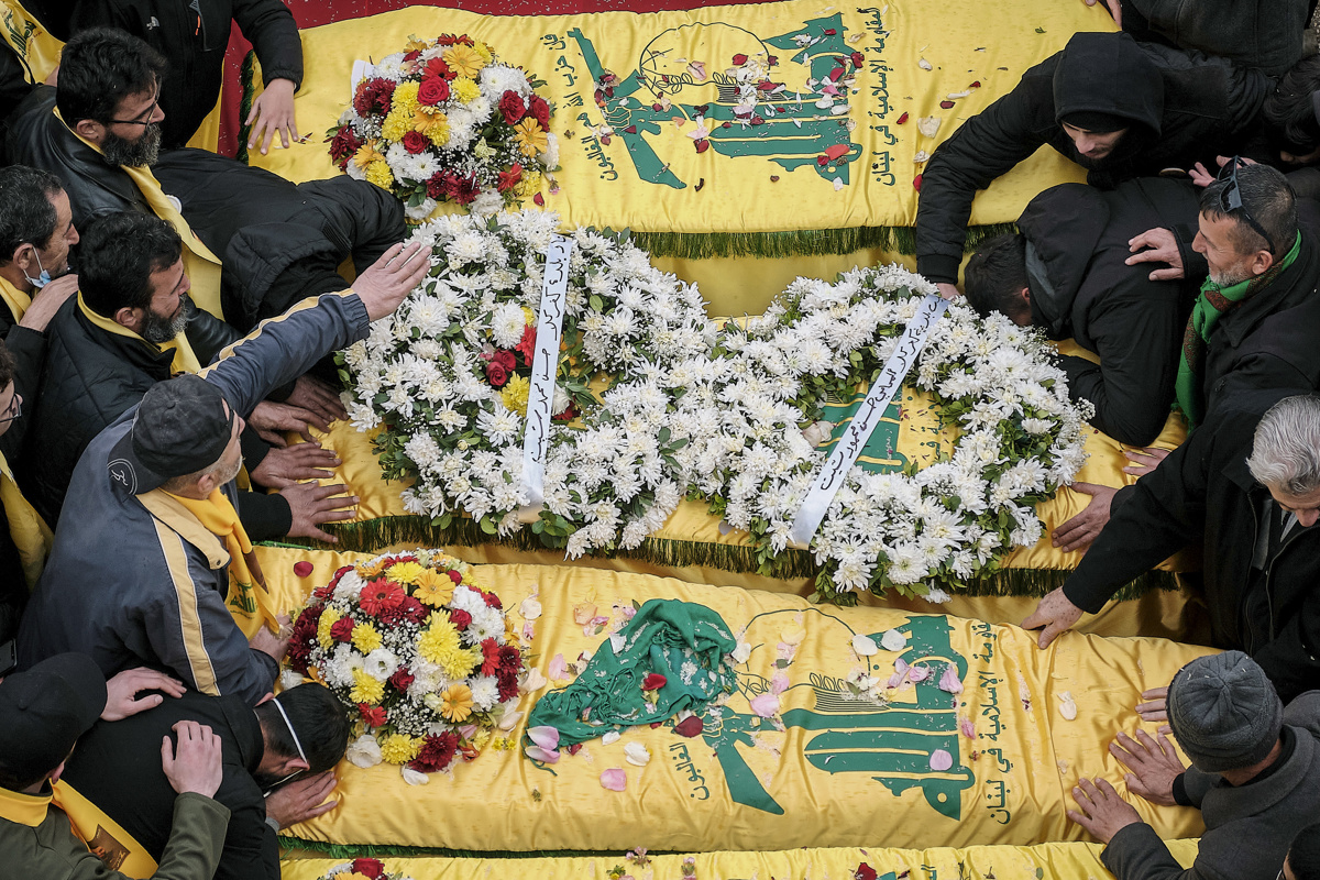 Familiares de los miembros muertos de Hizbulá rodean los féretros en la plaza principal de Jiam. (Foto de Edgar Gutiérrez de la agencia EFE)