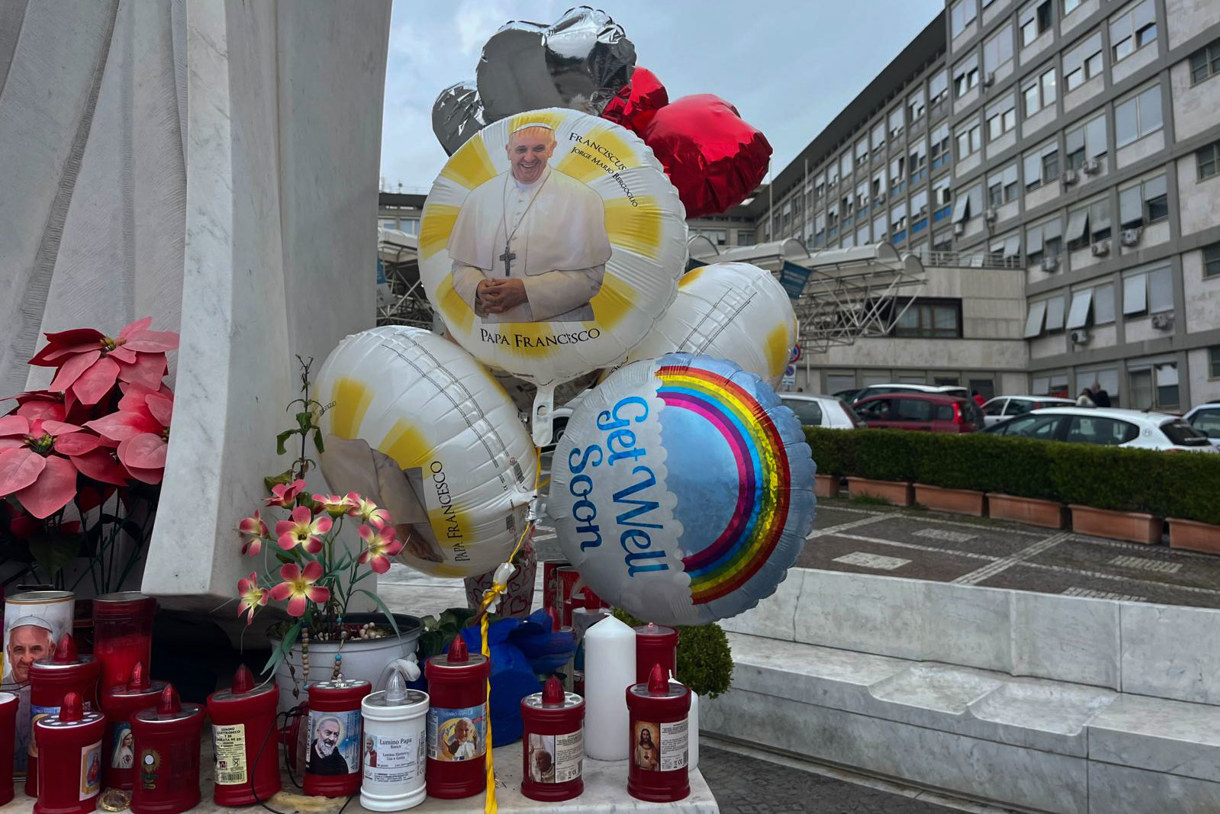 Cartas, globos y flores se acumulan en las puertas del hospital Gemelli en Roma, donde el papa Francisco permanece ingresado en estado crítico y al que cada día se acercan decenas de fieles y visitantes para rezar por su pronta recuperación. (Foto de Claudia Sacristán de la agencia EFE)