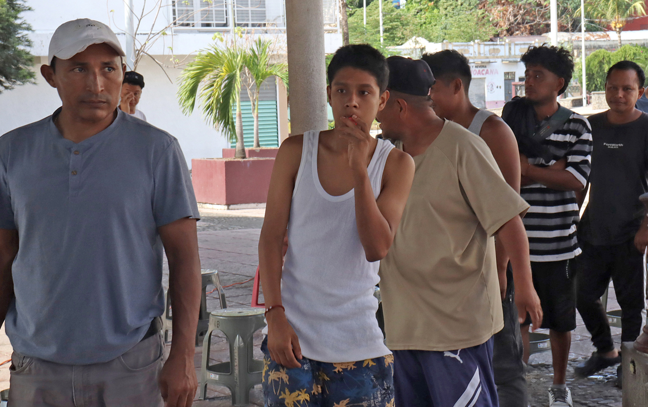 Personas reaccionan durante la espera para resolver su situación migratoria este domingo, en las principales plazas del municipio de Tapachula en el estado de Chiapas (México). (Foto de Juan Manuel Blanco de la agencia EFE)