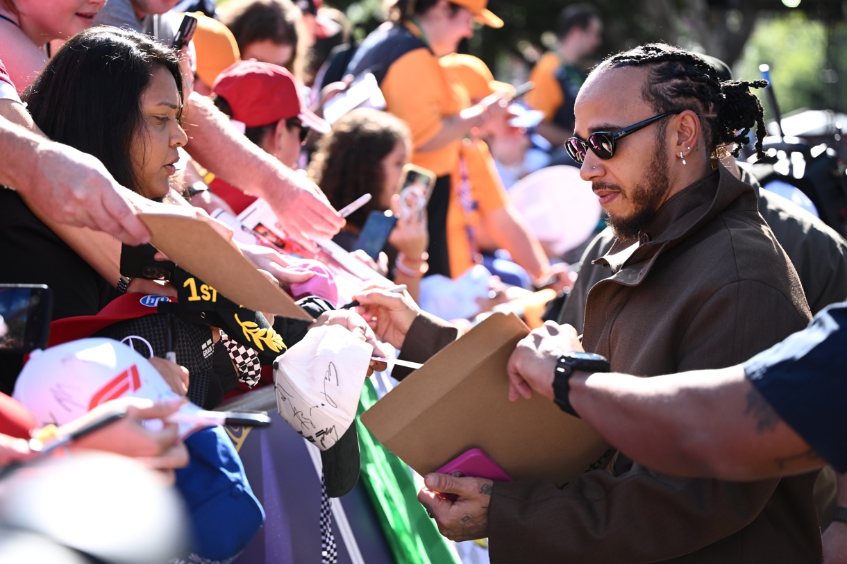 El piloto de Ferrari Lewis Hamilton firma autógrafos durante la sesión de entrenamientos libre de este viernes. (Foto de Joel Carrett de la agencia EFE/EPA)
