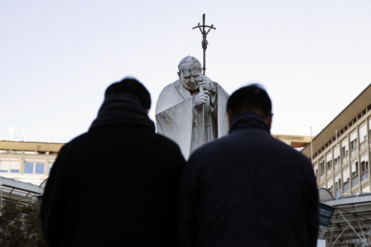 Fieles rezan frente a la estatua de Juan Pablo II en la entrada del Hospital Gemelli, donde está hospitalizado el Papa Francisco, en Roma, Italia, 05 de marzo de 2025. (Foto Angelo Carconi de la agencia EFE/EPA)