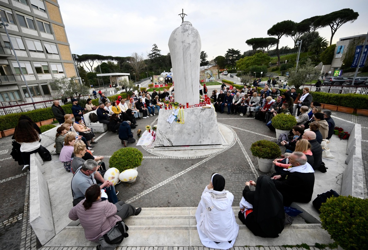 Un grupo de peregrinos rusos se reúne junto a la estatua de Juan Pablo II en la entrada del Hospital Gemelli, donde está hospitalizado el Papa Francisco, en Roma, Italia, el 11 de marzo de 2025. (Foto Alessandro Di Meo de la agencia EFE/EPA)