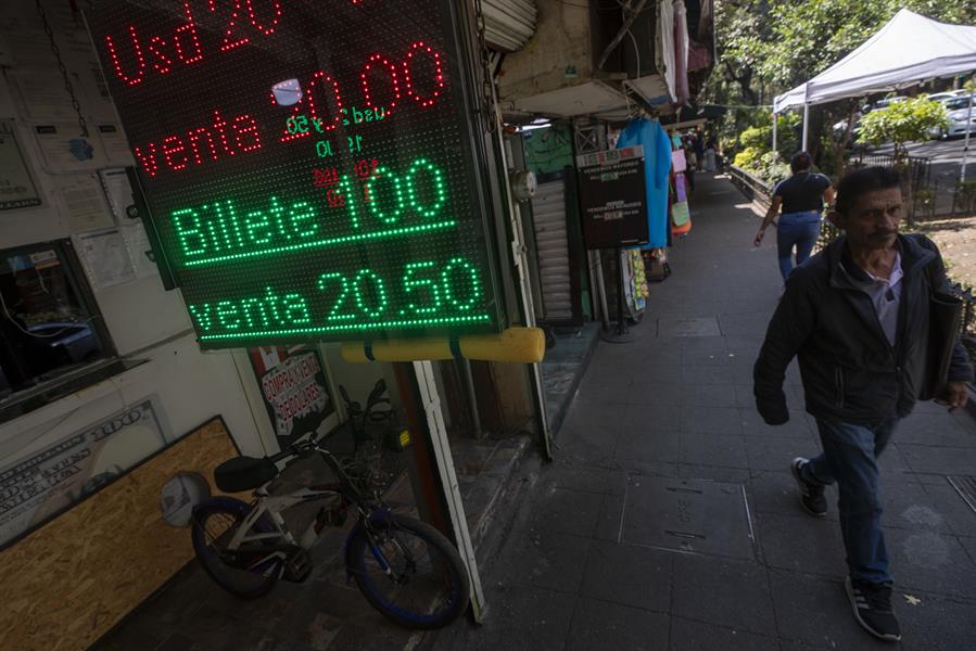 Personas caminan frente a una casa de cambio en Ciudad de México (México), en una fotografía de archive de EFE.