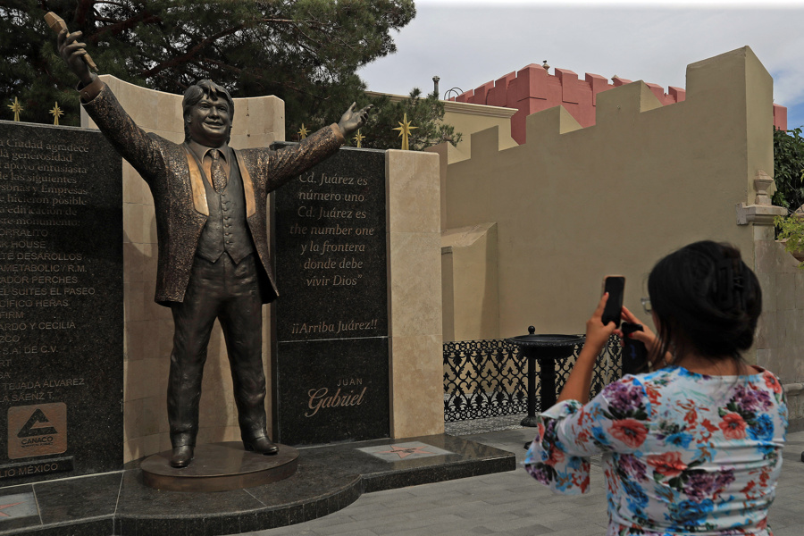 Una mujer toma una fotografía de la estatua del cantautor mexicano Juan Gabriel este 25 de mayo de 2025, en Ciudad Juárez, Chihuahua. (Foto de EFE)