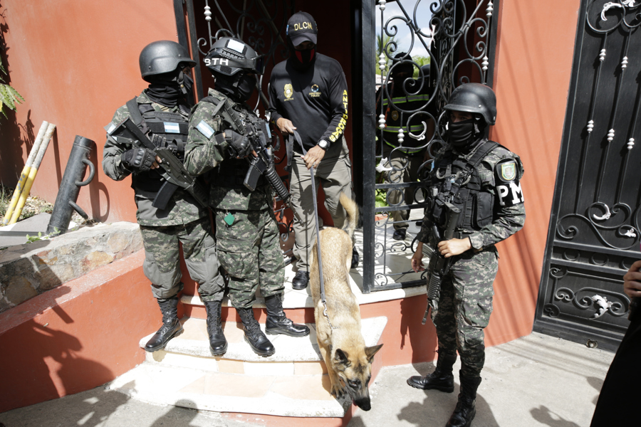 Militares hondureños acompañan a un agente de la Dirección de Lucha Contra el Narcotráfico (DLCN) en el allanamiento de la residencia del exjefe del Estado Mayor Conjunto de las Fuerzas Armadas de Honduras Romero Vásquez. (Foto de EFE)