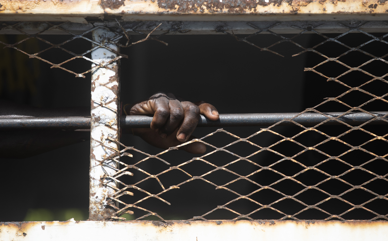 Fotografía de archivo en donde se ve la mano de un migrante tras una reja. (Foto de Orlando Barría de la agencia EFE)