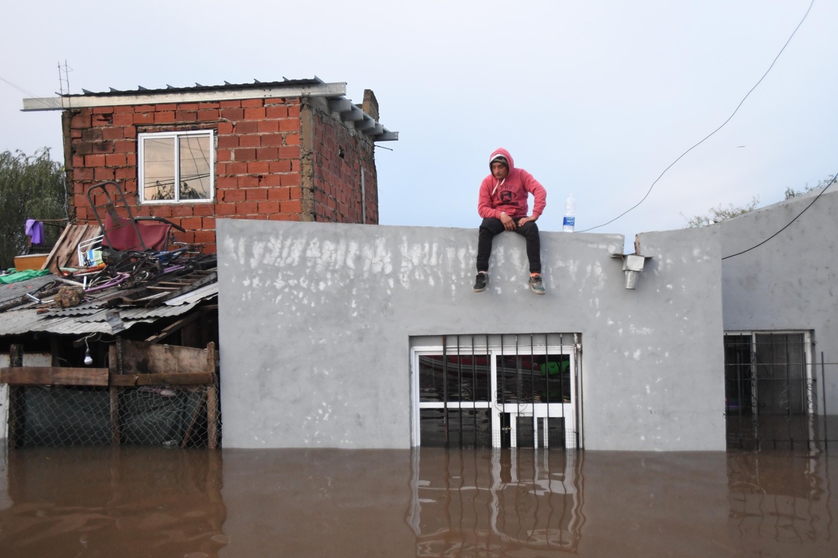 Una persona observa una inundación desde el techo de una vivienda este sábado, en Campana, Buenos Aires (Argentina). (Foto de STR/EFE)