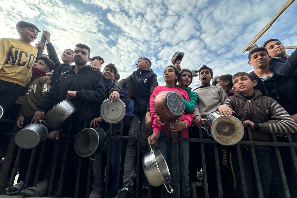 Decenas de niños se agolpan frente al centro de ayuda, instalado en una tienda de campaña en medio de edificios derruidos, esperando la ayuda humanitaria el 11 de marzo de 2025. (Foto de la agencia informativa EFE/Gaza)