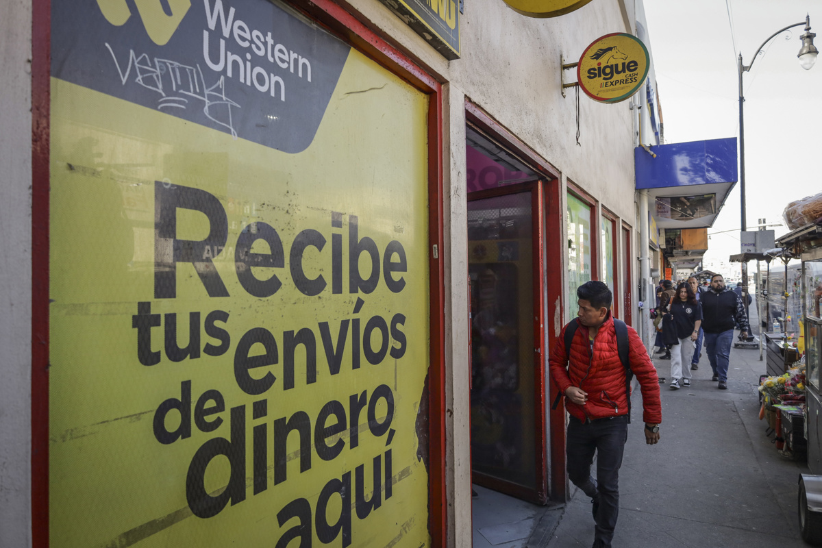 Una persona camina frente a un establecimiento de envío de dinero en Tijuana. ( Fotografía de archivo de Joebeth Terríquez de la agencia EFE)