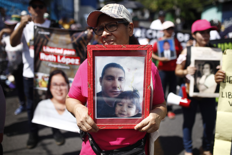Una mujer sostiene una fotografía durante una manifestación en San Salvador, El Salvador. (Foto de EFE)
