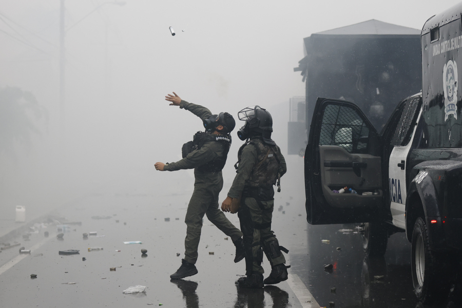 Un integrante de la Unidad de Control de Multitudes (UCM) lanza una granada de gas lacrimógeno durante una manifestación este sábado, en Changuinola en Bocas del Toro, Panamá. (Foto de EFE)